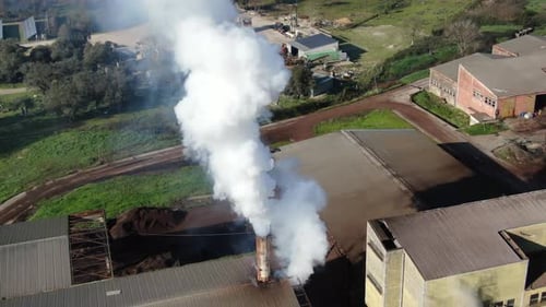 Close-Up Aerial Orbit of Factory Smokestack Emitting Billowing White Smoke