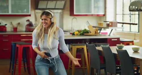 Energetic Woman Dancing to Music in Kitchen
