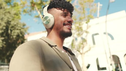 Close up, young student in headphones works on pc laptop while sitting on bench
