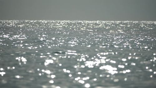 Blurred Golden Sea at Sunset with Shifting Focus and Bokeh Effect Sun Reflects and Sparkles on Waves