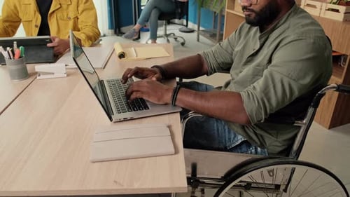 Man in Wheelchair Working on Laptop at Studio