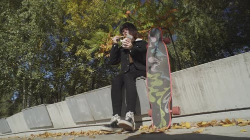 Young Adult Eating Noodles Next to Skateboard