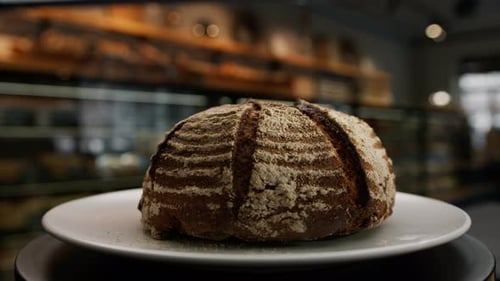 Close-up, bakery - freshly baked dark bread on a rotating surface
