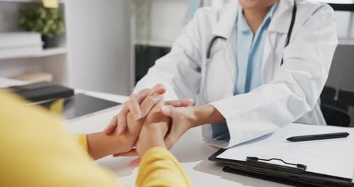 Caring Doctor Comforts Patient by Holding Hands