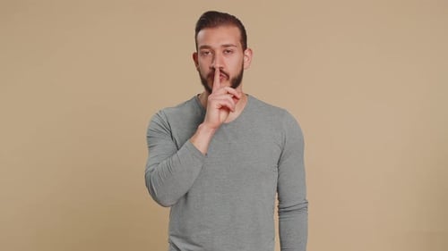 Un joven libanés se pone el dedo en los labios y hace un gesto de silencio, una señal de no contar un secreto, deja de cotillear