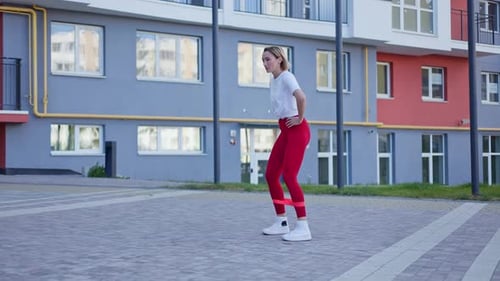 Young Woman Exercising Outdoors With Resistance Band
