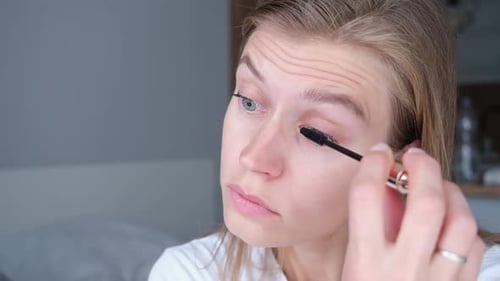 Woman Applying Mascara in her Home