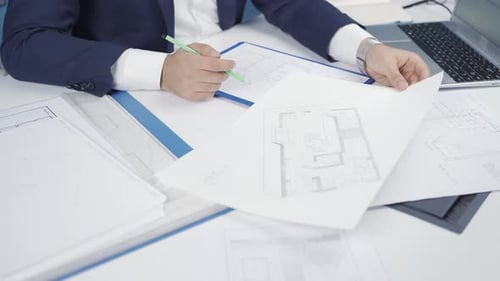 Architect Engineer looking at perspective hand drawings in his office.