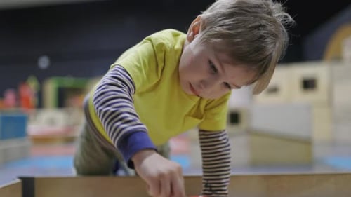 Focused Little Boy Playing with Toys