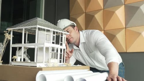 Gros plan d'un ingénieur caucasien qualifié inspectant un modèle de maison. Manipulateur.