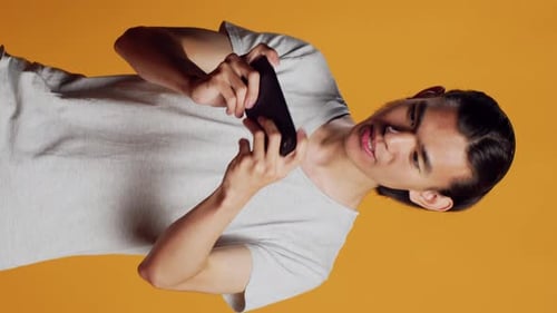 Vídeo vertical: modelo masculino feliz jogando Vídeo no smartphone