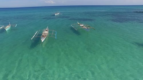 Philippine fishing ships resting in beautiful calm ocean, aerial shot