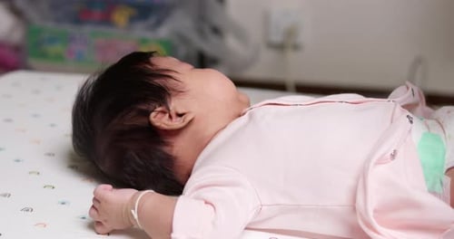 Caring for an Infant Lying on a Bed