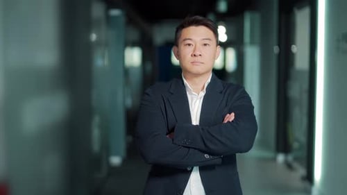 portrait of a successful confident asian male office worker standing and looking at the camera