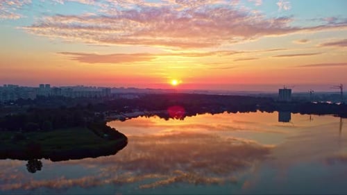 Sunrise on river with vibrant clouds