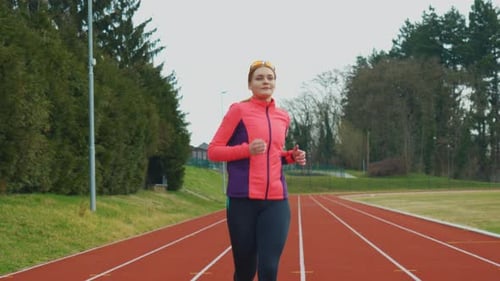Auburn Haired Woman Jogging on Outdoor Running Track