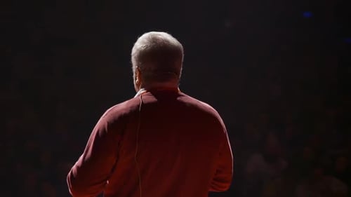 Man Speaker at Business Conference Stage Talking to People Sitting in Auditorium