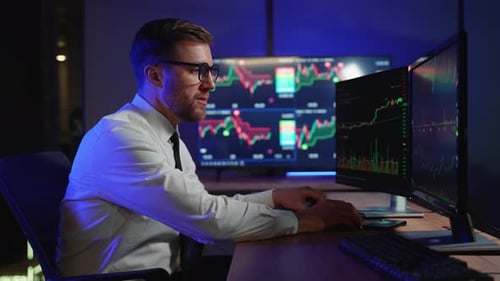 Shocked Stressed Businessman Sitting at Workplace in Dark Office Looks Like a Bitcoin Going Down