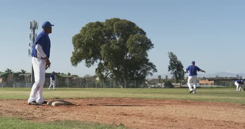 Playing baseball, athletes on field competing in game, wearing uniforms and helmets