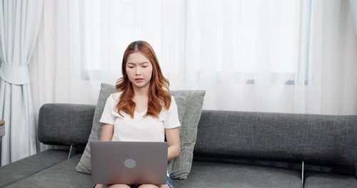 Young Woman Stretching Wrists While Using Laptop
