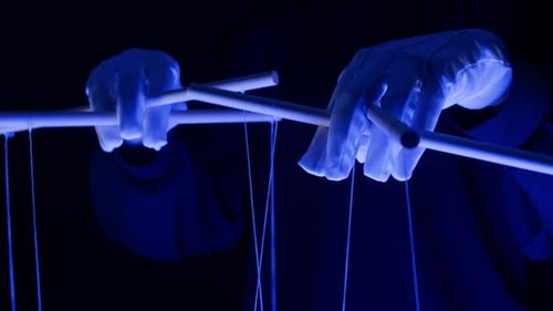 The Puppeteer Controls the Puppets in the Theater in Blue Neon Light Closeup Managing People at Work