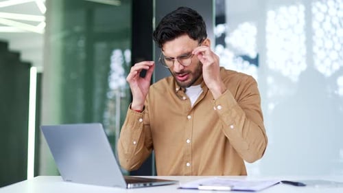Man Experiencing Eye Strain While Using Laptop