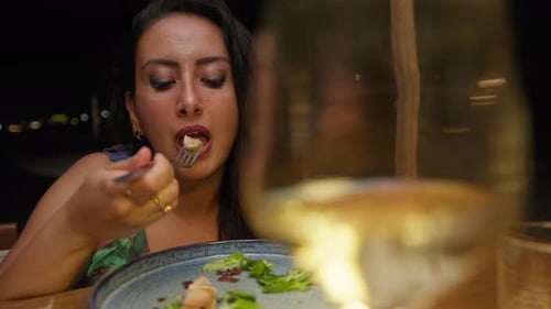 Elegant Woman Dining at Outdoor Restaurant at Night