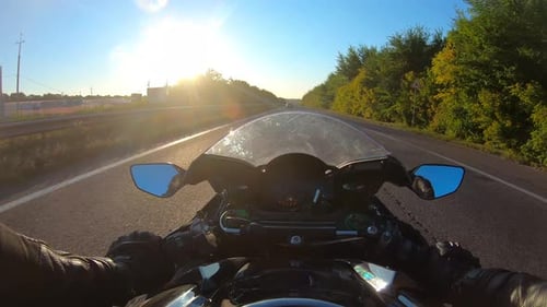 Point of View of Motorcyclist Driving Motorbike at Highway with Sun Flares The Viewpoint of