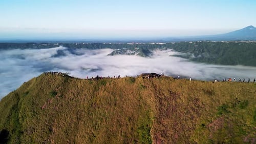 Randonnée sur la crête du mont Batur au-dessus des nuages avec des pentes abruptes et des vues panoramiques sur les hautes terres de Bali