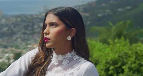A girl wearing an antique-style wedding dress standing under an archway in a fort.