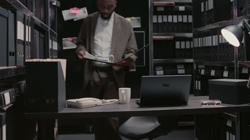 Young Policeman Examining Forensic Evidence in Office
