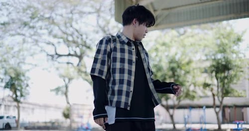 A hip-hop young man enjoys freestyle dancing in an outdoor pavilion.