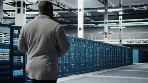 Admin Walking in Data Center Doing Inspection on Infrastructure Tech