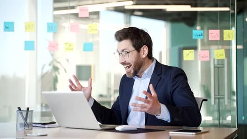 Excited Man Works on Laptop in Office