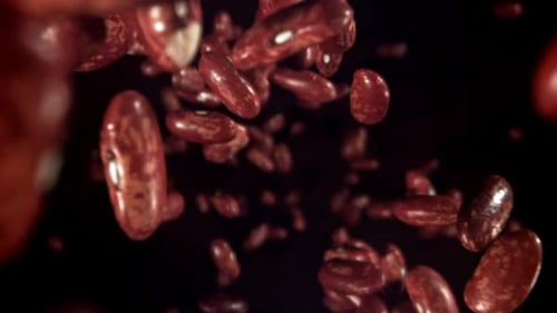 Shiny Red Kidney Beans Floating on Black Background