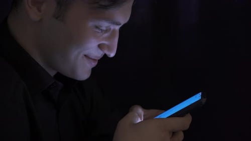 Young Man Texting Close-Up with Smartphone and Looking.