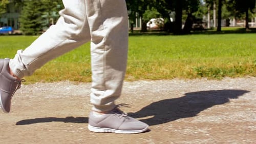 Man Wearing Sneakers Jogging Through Park