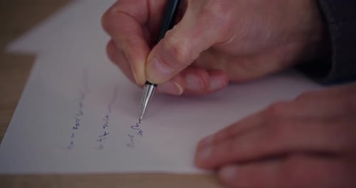 Hands of Senior Businessman Writing Strategy on Paper at Desk