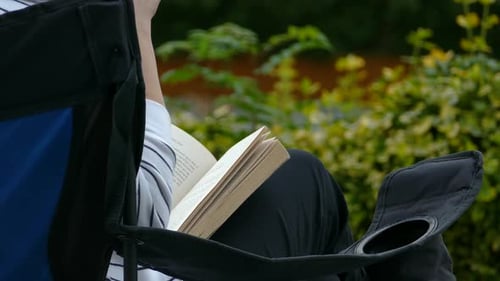 Woman Enjoying a Book Outdoors in Camping Chair