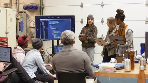 Hacker sprechen während des Hackathons 2024 über Computercode