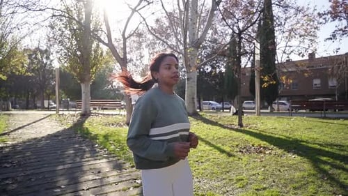 Young African American Slim Woman Runner Jogging in the Morning in Urban Park in Tracksuit Slow