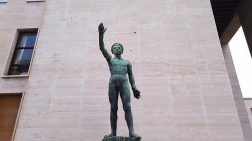 Statue located in EUR, a business district of Rome. It is made of copper and represents a male adult
