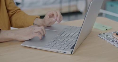 Young Adult Typing on Laptop at Home Office