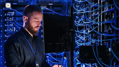 Man Working With Computer Servers at Night