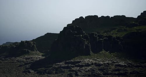 Rocky Cliffs Rise Majestically Under a Hazy Sky Overlooking the Ocean