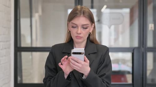 Woman using smartphone in office environment