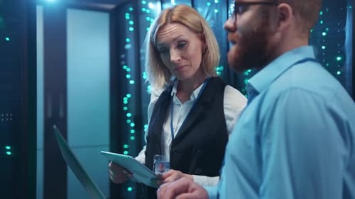 In a Hightech Server Room a Man and a Woman Analyze Data Together
