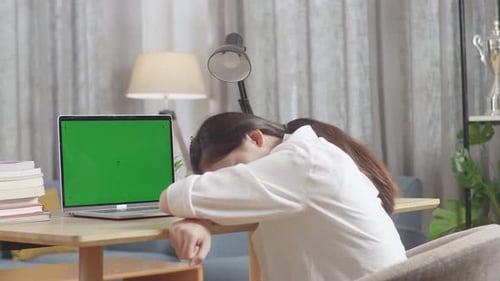 Back View Of Tired Asian Teenager Sleep On The Table At Home After Doing Home Work