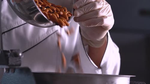 Almonds Being Poured into Metal Bowl in Kitchen