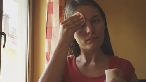 Woman Applying Facial Product with Cotton Pad